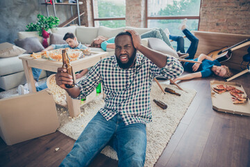 Afro american man sit floor carpet touch head hand have migraine hold empty beer bottle cant remember night bachelor party event celebration suffer handover fellows sleep in house indoors