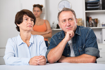 Adult couple is upseting and their daughter is sympathying with them at home.