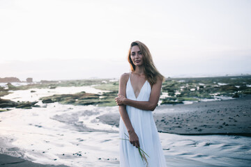 Fototapeta na wymiar Sensual woman standing on sandy shore