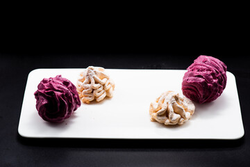 Delicious marshmallows on a plate on a dark background