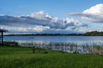 view of a large beautiful lake against the backdrop of clouds and blue sky