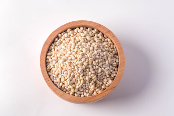 Barley rice in a wooden cup on a white background