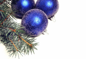 Winter composition with blue Christmas balls and a fir branch.