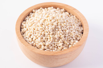 Barley rice in a wooden cup on a white background