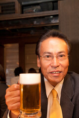 ビールを飲むビジネスマ人物、男性、日本人、会社員、男性社員、ビジネスマン、サラリーマン、居酒屋,飲食店,お酒,飲み物,飲む、ビール,ビールジョッキ、持つ、仕事帰り、ン