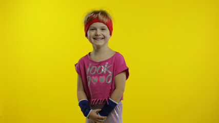 Fototapeta premium Little happy caucasian girl in pink sportswear smiles, laughs. Workout for kids. Young sporty child