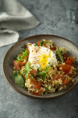 Fototapeta na wymiar Healthy warm bulgur salad with poached egg