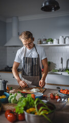 Handsome Man in White Shirt and Apron is Making a Healthy Organic Salad Meal in a Modern Sunny Kitchen. Hipster Man in Glasses Cooking. Natural Clean Diet and Healthy Way of Life Concept.