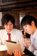 居酒屋でタブレットＰＣを見るビジネスマン