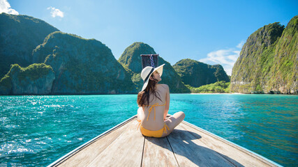 View of woman in swimsuit enjoying on thai traditional longtail Boat over beautiful mountain and...