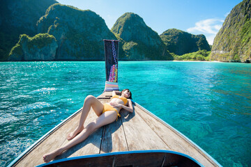 View of woman in swimsuit enjoying on thai traditional longtail Boat over beautiful mountain and...