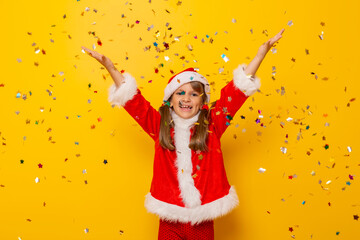 Little girl dressed as Santa throwing confetti