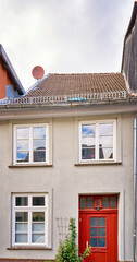 Small old house with red wooden door in the old town.