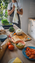 Shot of a Kitchen Table with Vegetables and Cauliflower on a Cutting Board. Healthy Organic Green Food in a Modern Sunny Kitchen. Natural Clean Diet and Healthy Way of Life Concept.