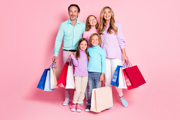 Full length photo of full family people enjoy shopping dad daddy mom mommy three little small children hold bags isolated over pastel color background