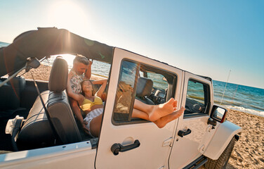 Naklejka premium Couple on beach with car