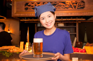 ビールを運ぶ居酒屋店員