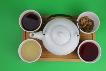 japanische Teekanne mit kleinen weißen Teetassen und unterschiedlichen Teesorten 