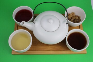 Obraz na płótnie Canvas japanische Teekanne mit kleinen weißen Teetassen und unterschiedlichen Teesorten 