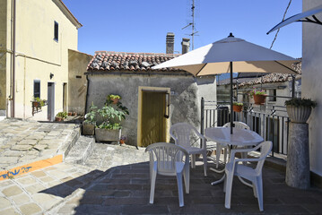 A small road crosses the old buildings of Grumento Nova, a rural village in the Basilicata region, Italy.