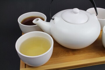 japanische Teekanne mit kleinen weißen Teetassen und unterschiedlichen Teesorten 