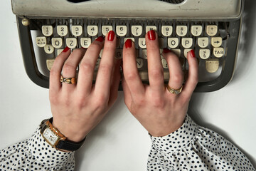 Hands of a secretary with typewriter on white background