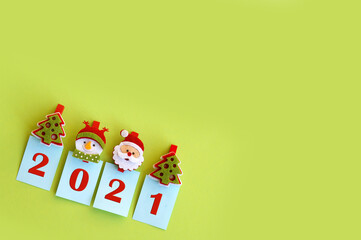 Fototapeta premium Year 2021 on a green background and symbols of the winter holiday.