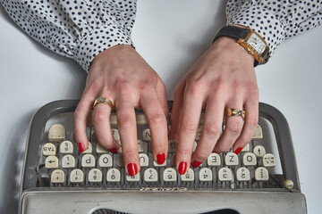 Hands of a secretary with typewriter on white background