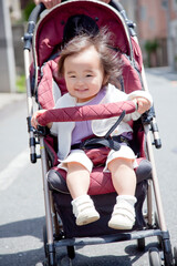 ベビーカーに乗って散歩する女の子