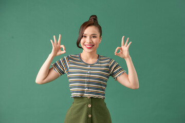 Attractive young adult woman showing ok sign.