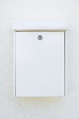 white metal mailbox on a white wall