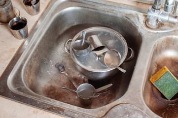 Dirty dishes in a very dirty steel sink, close-up