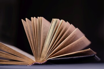 Opened old book with gold pages on a black background