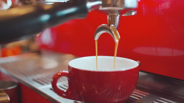 Barista making an espresso shot coffee pouring from a coffee machine into a cup, coffee machine