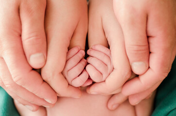 Obraz na płótnie Canvas Pregnancy, maternity, preparation and expectation motherhood, giving birth concept. Newborn baby hands closeup in parents hands