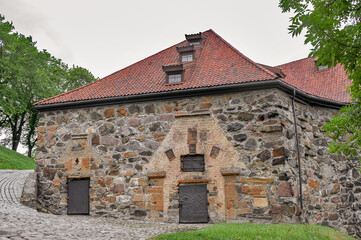 Fototapeta premium View of restored fortres buildings fnd fortifications built of large granite stones on a cloudy summer day