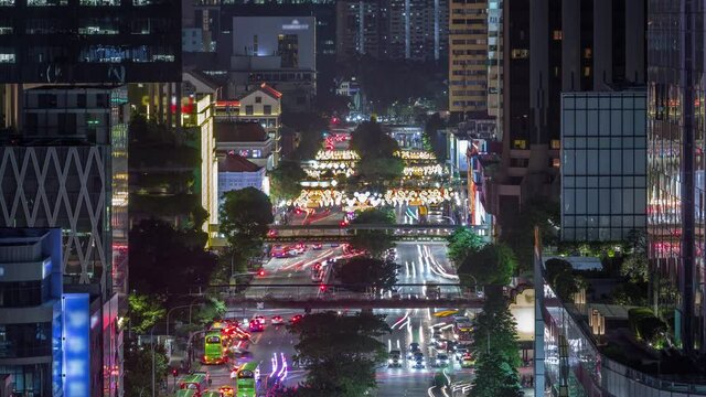 Traffic with cars on a street and urban scene in the central district of Singapore aerial day to night transition timelapse. New bridge road in chinatown after sunset. Downtown skyscrapers around