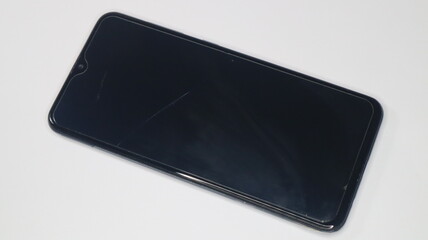 black mobile phone with cracked tempered glass