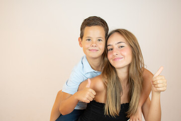 Two smiling brothers with thumbs up on white background