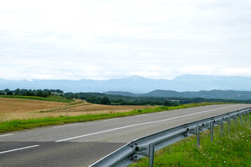 The beautiful mountain road crossing the valley with colorful green and yellow field, blossoming meadow and deep forest in Pyrenees near the last cathar fortress Montsegur in the south of France