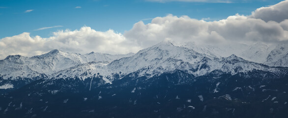 Beautiful alpine landscape, blue sky, clouds and snow on mountain peak. Panorama banner format