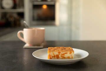 A piece of cheesecake with pumpkin filling is on the table