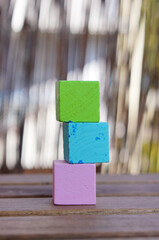 Three colorful wooden toy blocks