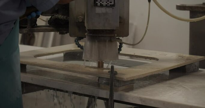 Cabinet maker milling a sink hole in a granite worktop with a commercial router. 
