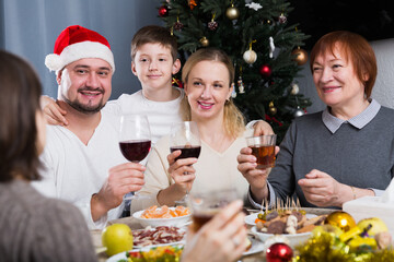 Portrait of large friendly family during celebration of New Year at table at home