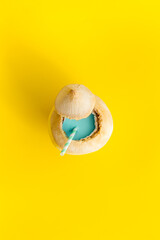Coconut drink with drinking straw, top view