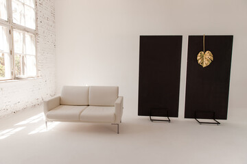 Big white sofa in trendy white photo studio