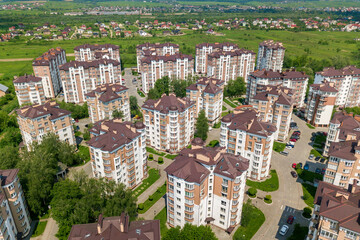 Fototapeta premium Top view of apartment or office tall buildings, parked cars, urban city landscape. Drone aerial photography.
