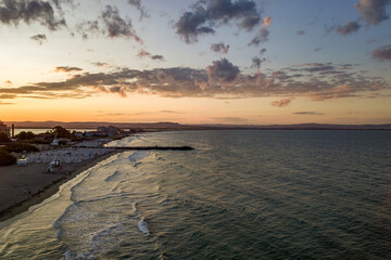 Sea surface with blue water waves under yellow and purple sunset sky.