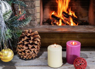 Christmas eve. Christmas tree, candles, cones and toys in front of cozy fireplace.